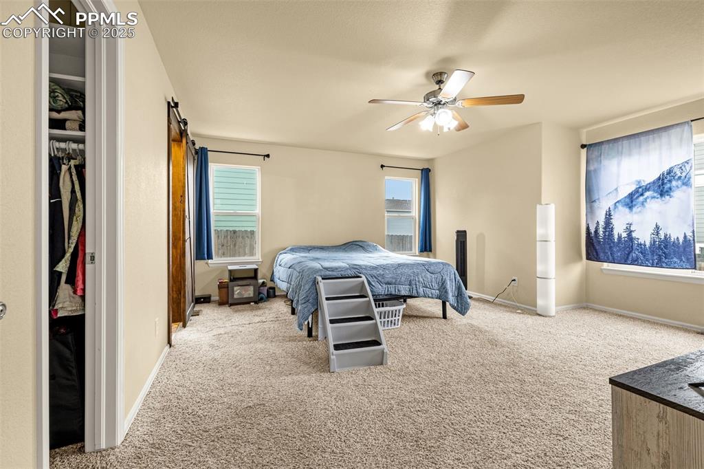 Image 15 of 36: Bedroom featuring light colored carpet, ceiling fan, and a closet