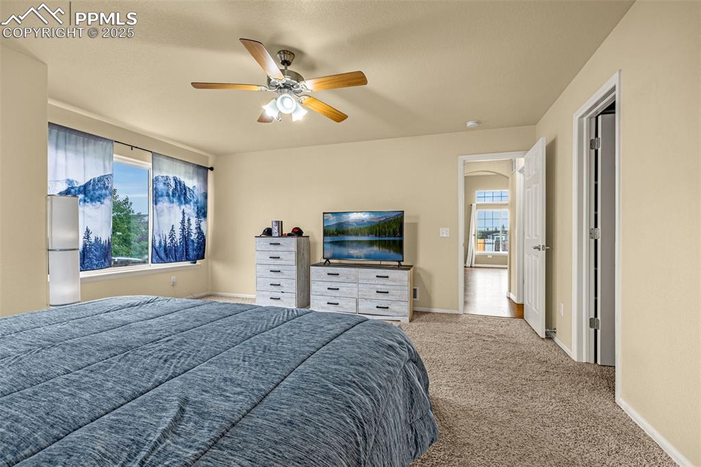 Image 16 of 36: Bedroom with carpet flooring, a ceiling fan, and freestanding refrigerator