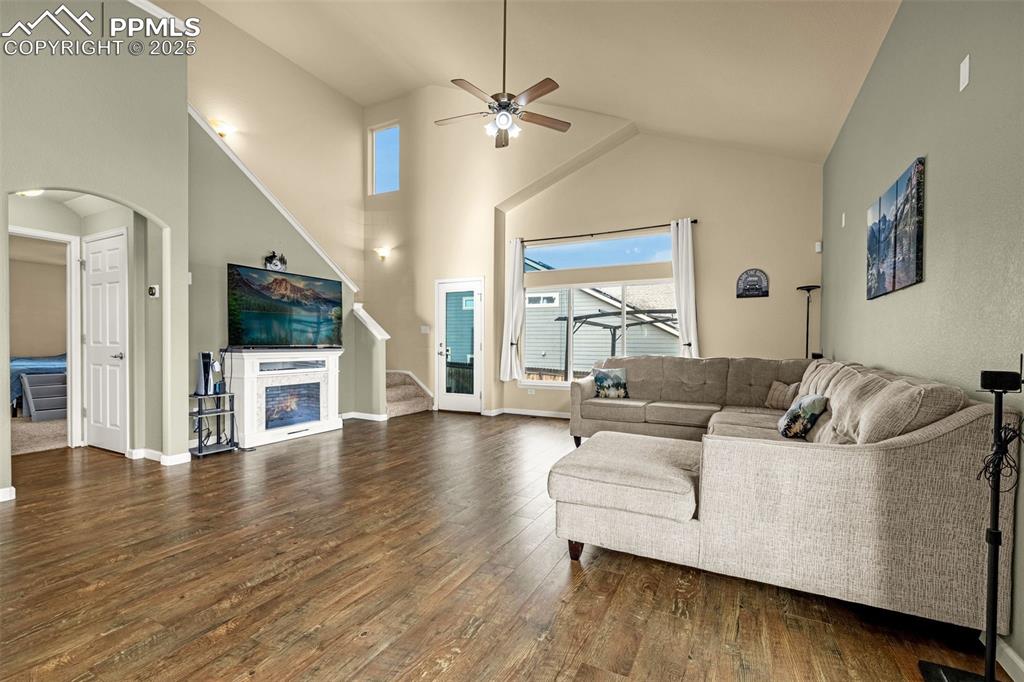 Image 2 of 36: Living room featuring high vaulted ceiling, a glass covered fireplace, dark