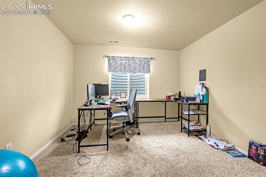 Image 24 of 36: Carpeted office space featuring a textured wall and a textured ceiling
