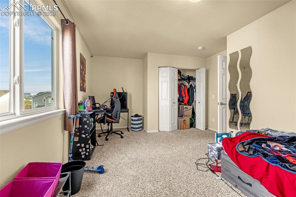 Image 26 of 36: Bedroom with carpet floors, a closet, and an office area