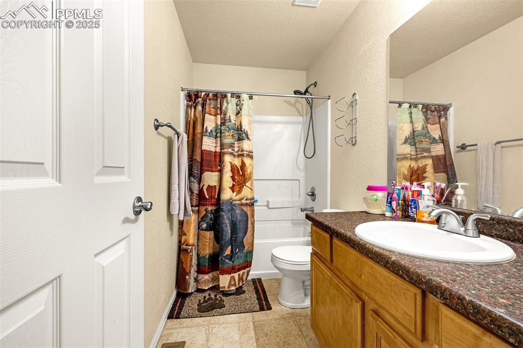 Image 27 of 36: Full bath with vanity, a textured ceiling, shower / bath combination with c