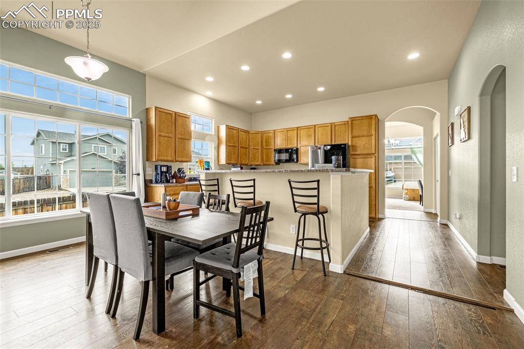 Image 3 of 36: Dining room with arched walkways, recessed lighting, and dark wood finished