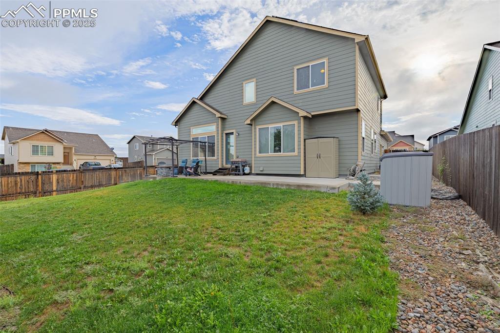 Image 30 of 36: Back of property featuring a fenced backyard, a patio area, and a shed
