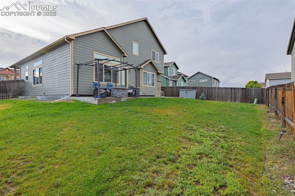 Image 31 of 36: Rear view of house featuring a fenced backyard and a patio