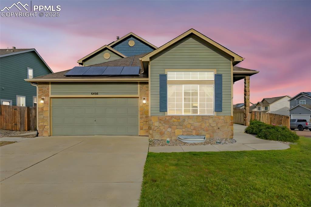 Image 36 of 36: View of front of home featuring stone siding, roof mounted solar panels, dr