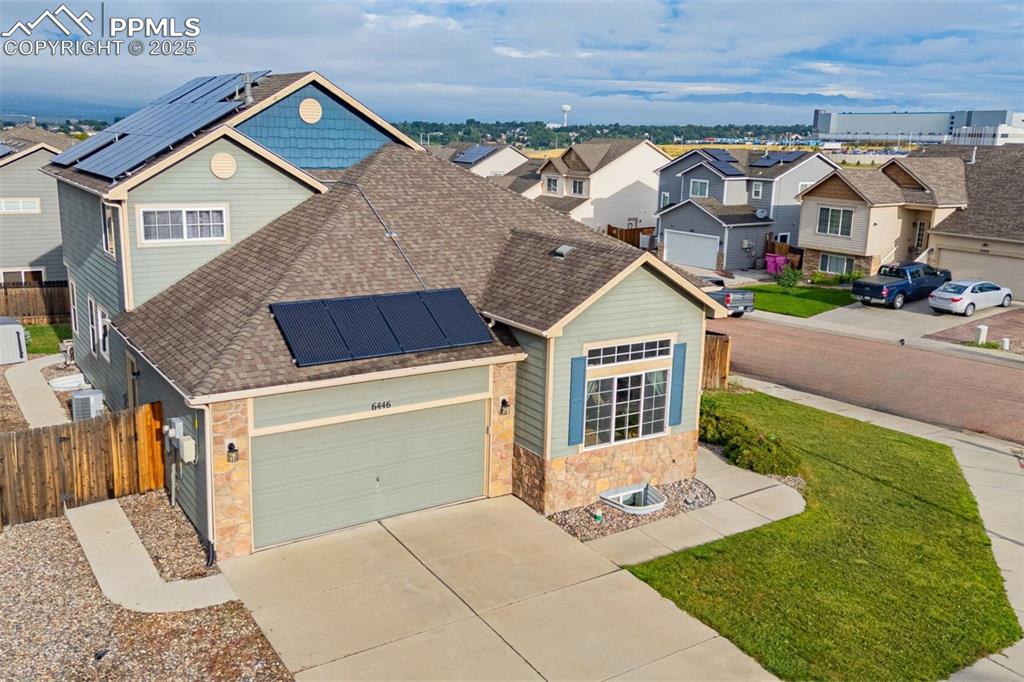 Image 6 of 36: Traditional-style home featuring solar panels, roof with shingles, stone si