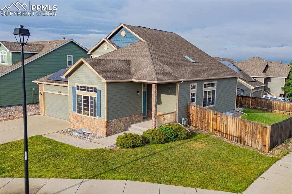 Image 7 of 36: View of front of property featuring a shingled roof, stone siding, concrete