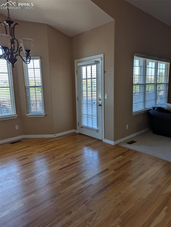 Image 11 of 33: Unfurnished dining area with light wood finished floors and a chandelier