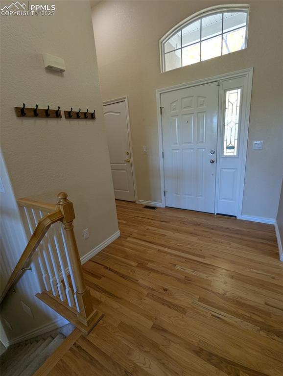 Image 2 of 33: Foyer featuring light wood-type flooring and a towering ceiling