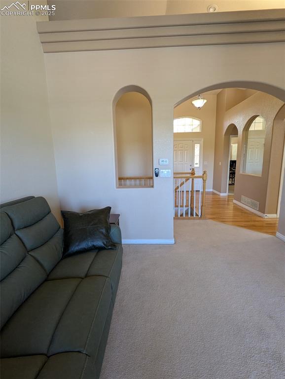 Image 3 of 33: Living area with arched walkways and light carpet