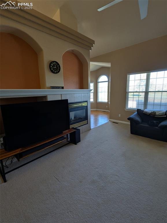 Image 5 of 33: Carpeted living room with a fireplace and a towering ceiling