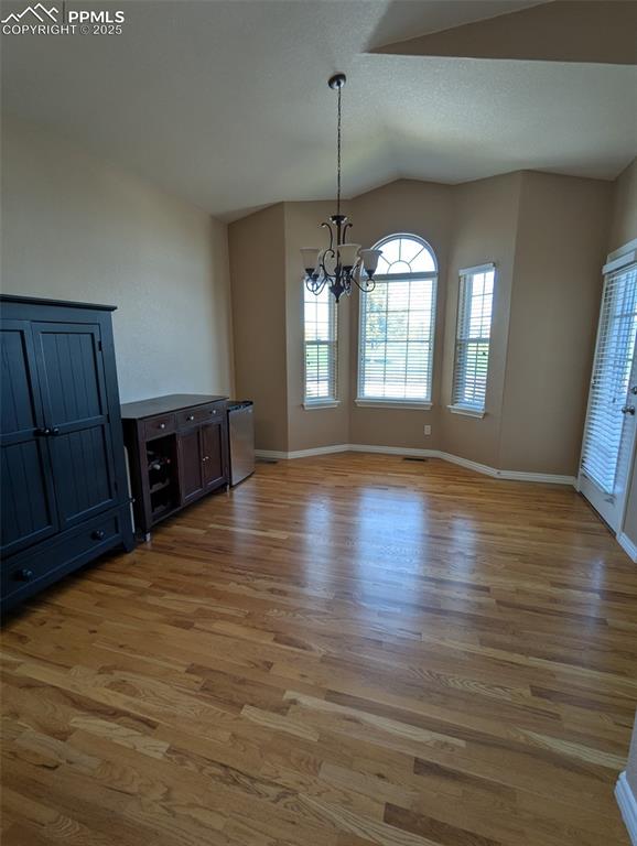 Image 6 of 33: Unfurnished dining area featuring a chandelier, light wood-type flooring, a