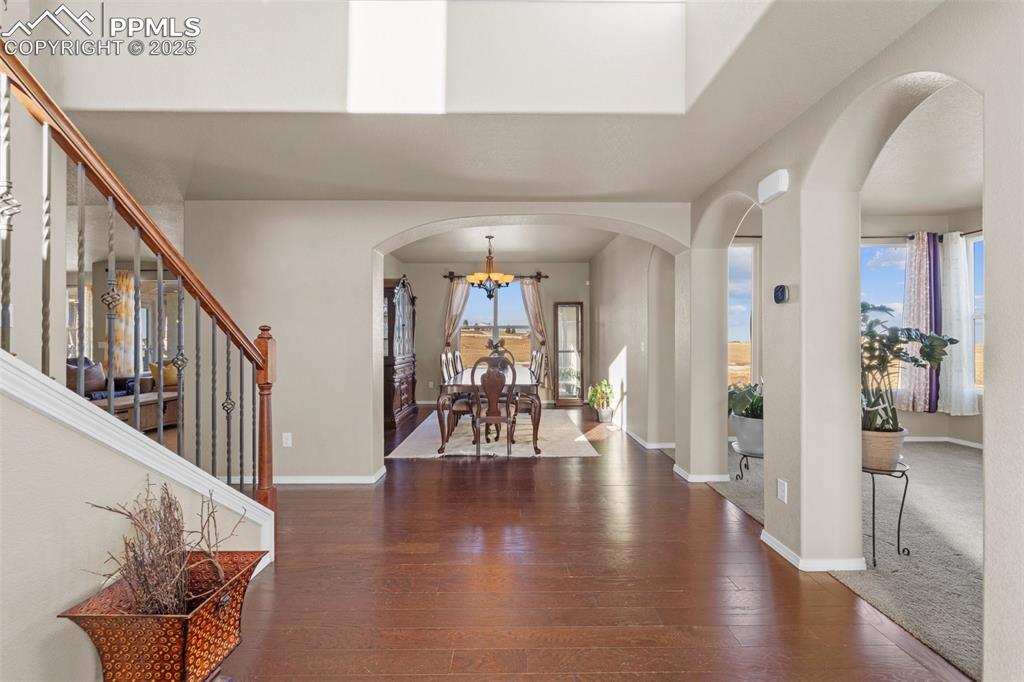 Image 12 of 50: Foyer entrance featuring dark hardwood / wood-style floors and a chandelier