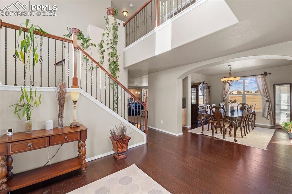 Image 13 of 50: Foyer entrance featuring an inviting chandelier, dark hardwood / wood-style