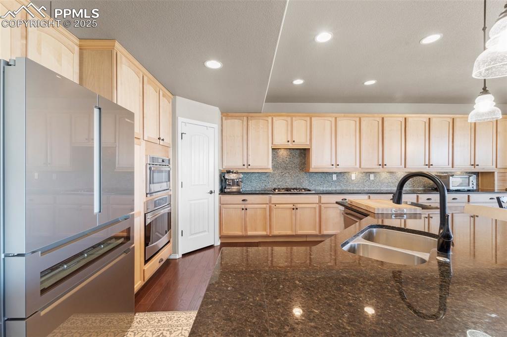 Image 22 of 50: Kitchen featuring sink, decorative light fixtures, light brown cabinets, ap