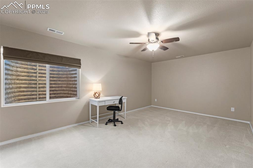 Image 32 of 50: Carpeted office featuring a textured ceiling and ceiling fan