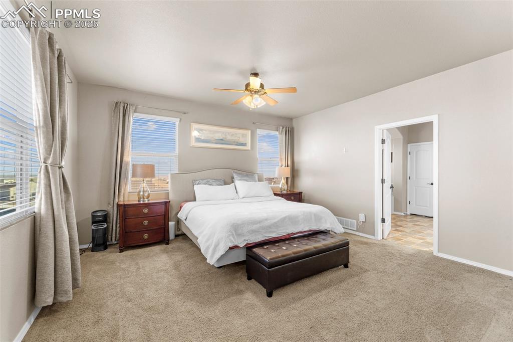 Image 42 of 50: Bedroom with light colored carpet and ceiling fan