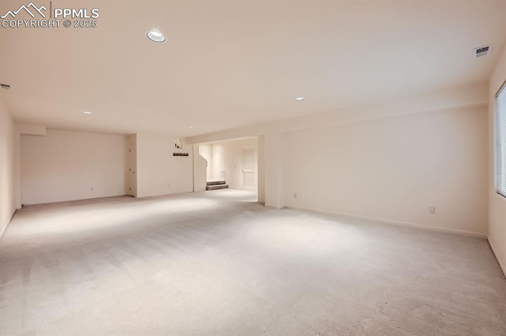 Image 17 of 27: Spare room featuring recessed lighting, stairs, visible vents, and light ca