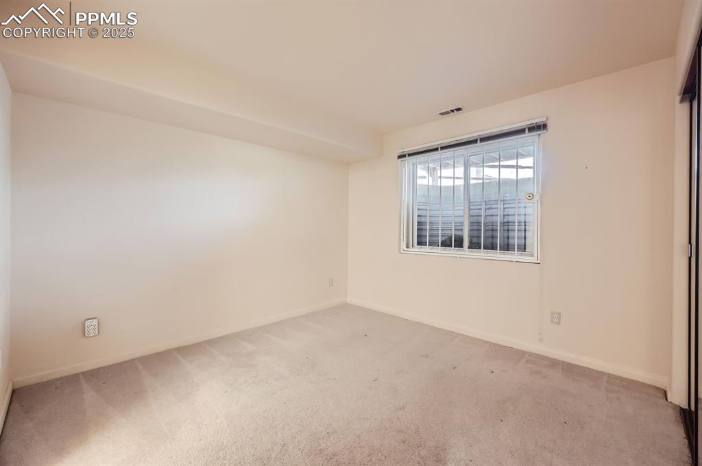 Image 19 of 27: Spare room featuring visible vents, light colored carpet, and baseboards