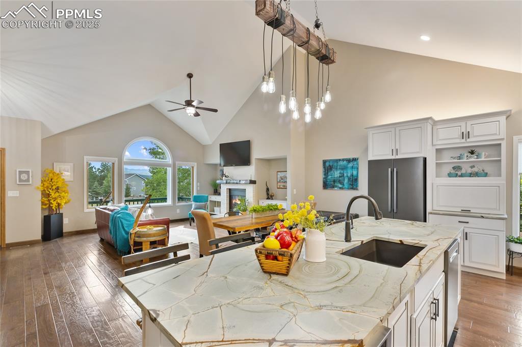 Image 13 of 44: Kitchen with high vaulted ceiling, open floor plan, open shelves, light sto