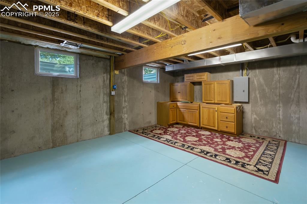 Image 35 of 44: Unfinshed basement area with cabinets and flooring ready to get you started