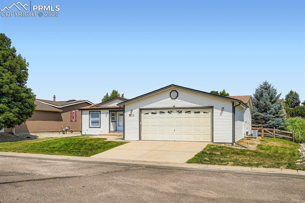 Caption: Ranch-style home with concrete driveway and an attached garage
