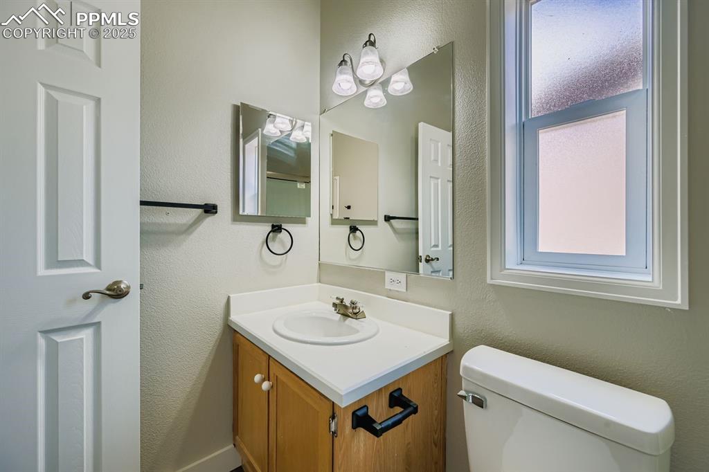 Image 12 of 28: Bathroom featuring a textured wall and vanity