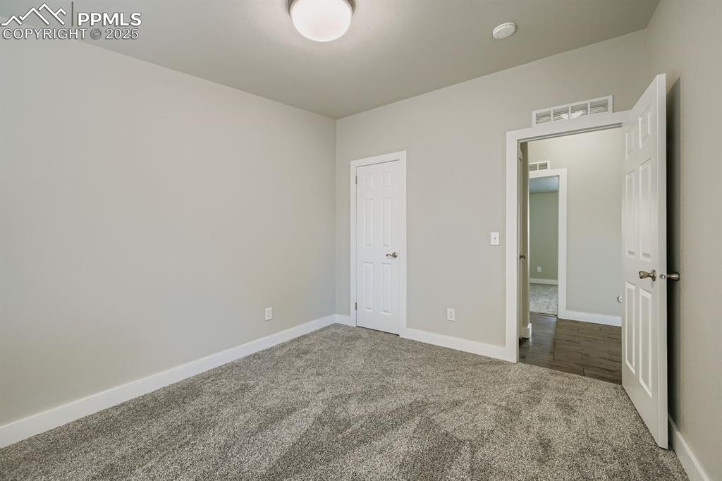 Image 13 of 28: Unfurnished bedroom with carpet floors and baseboards