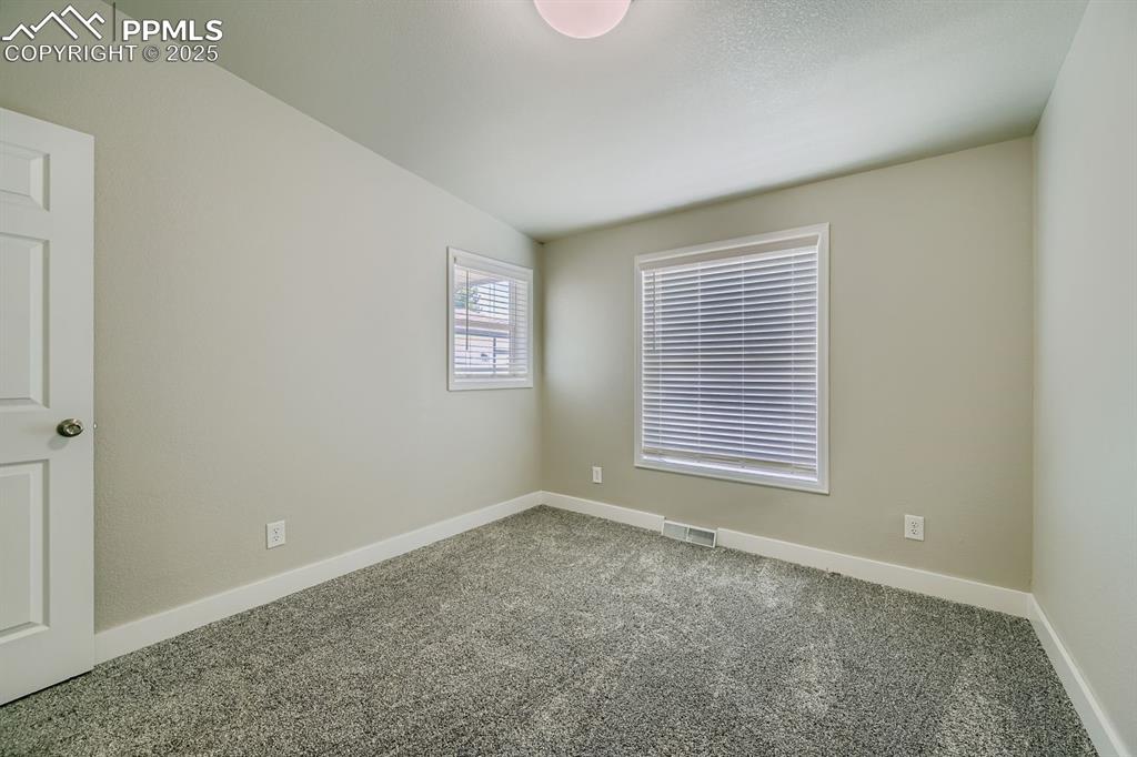 Image 14 of 28: Carpeted spare room with baseboards