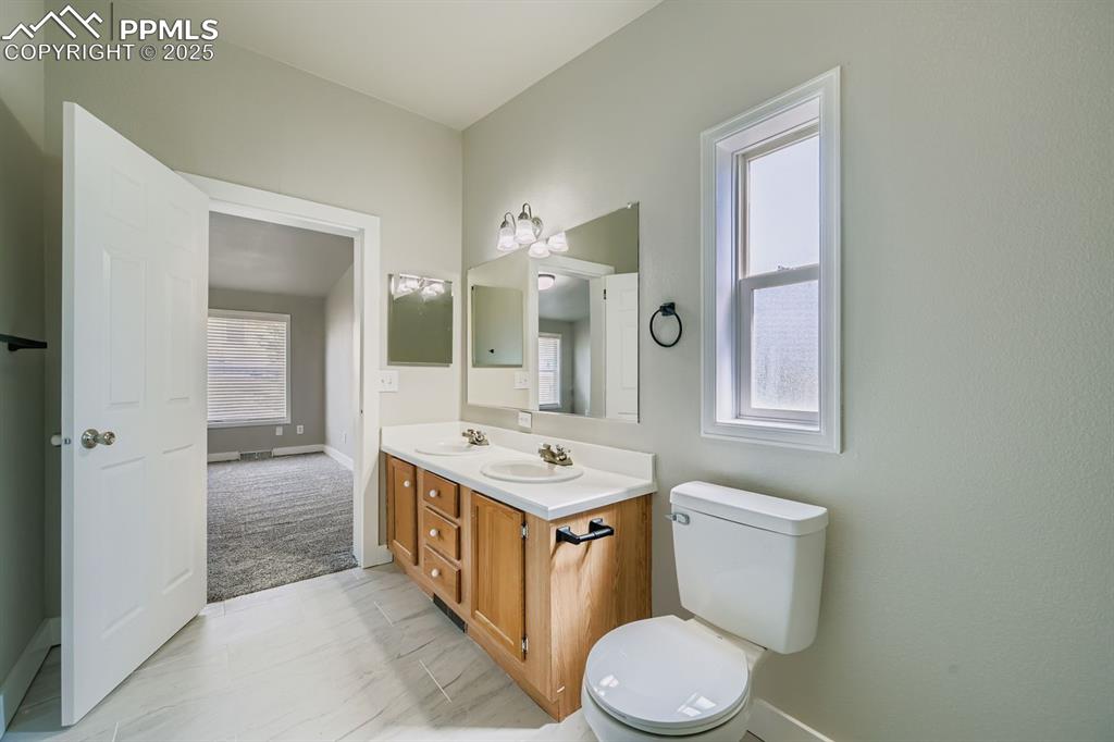 Image 16 of 28: Bathroom featuring double vanity and toilet