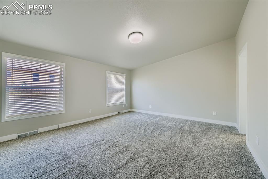 Image 21 of 28: Empty room featuring light colored carpet and baseboards