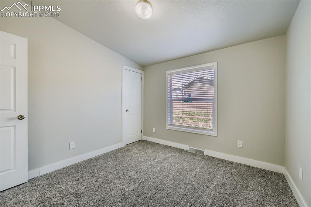 Image 23 of 28: Carpeted empty room with baseboards and vaulted ceiling