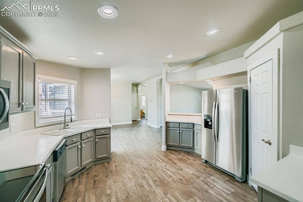 Image 4 of 28: Kitchen with appliances with stainless steel finishes, light countertops, g