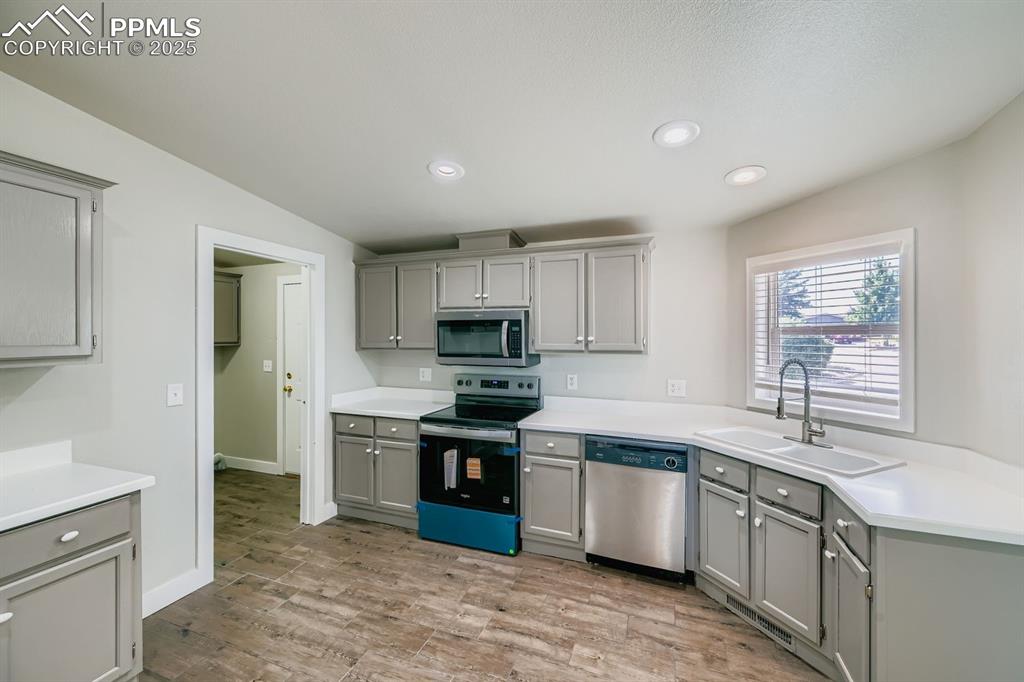 Image 5 of 28: Kitchen with gray cabinetry, stainless steel appliances, recessed lighting,