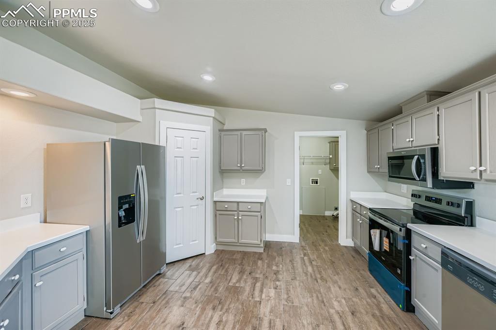Image 6 of 28: Kitchen featuring gray cabinets, stainless steel appliances, light wood-typ