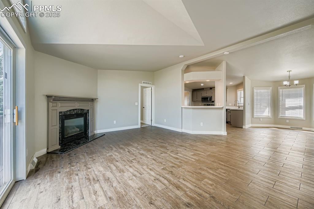 Image 9 of 28: Unfurnished living room with a fireplace, light wood-style flooring, recess