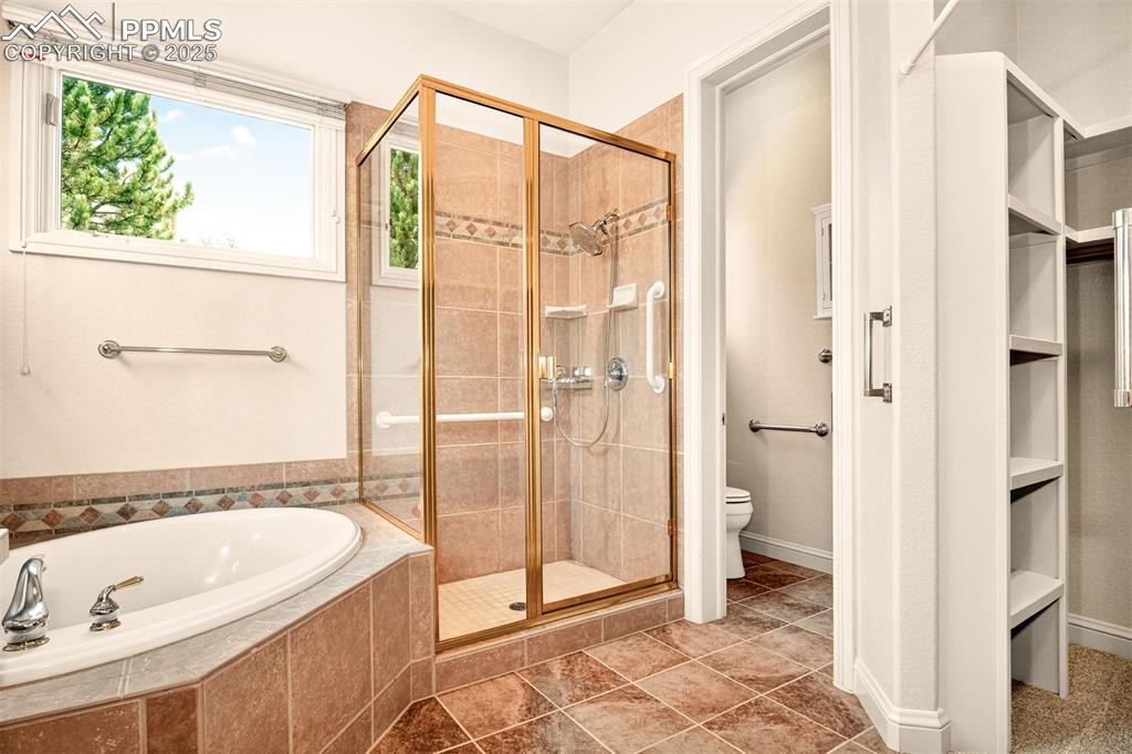 Image 12 of 35: 5 piece bath featuring a soaking tub, a stall shower, and new tile flooring