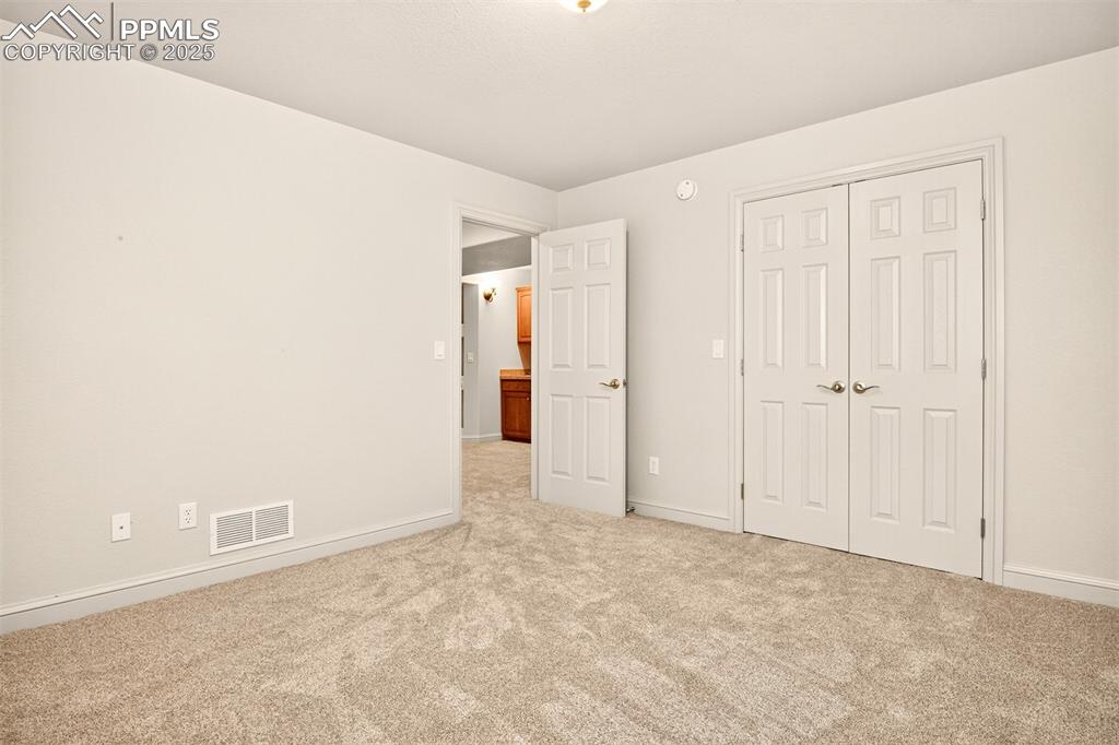 Image 26 of 35: Unfurnished bedroom with light carpet and a closet