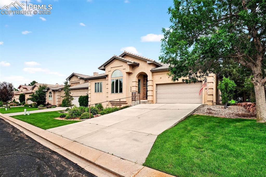 Image 3 of 35: Mediterranean / spanish-style home with stucco siding, driveway, a front ya