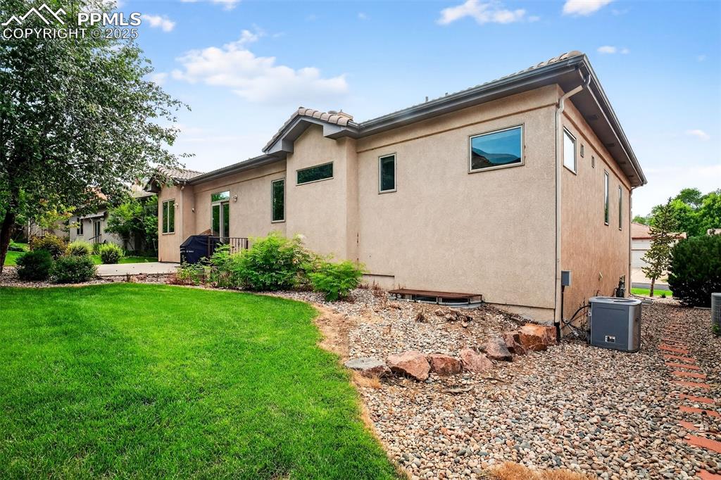 Image 32 of 35: Back of property featuring stucco siding and a lawn