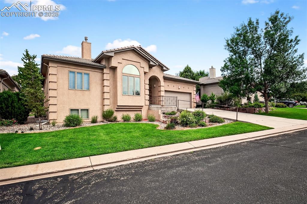 Image 4 of 35: Mediterranean / spanish-style house with a front yard, a chimney, stucco si