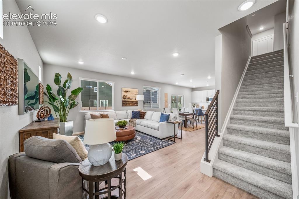 Image 11 of 23: Spacious open-concept living area featuring light wood-finish flooring and