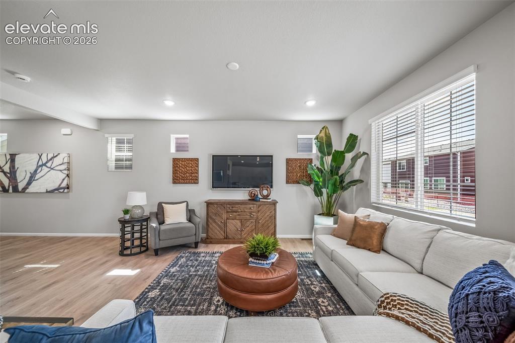 Image 14 of 23: Open-concept living area featuring wood-finish flooring, recessed lighting,