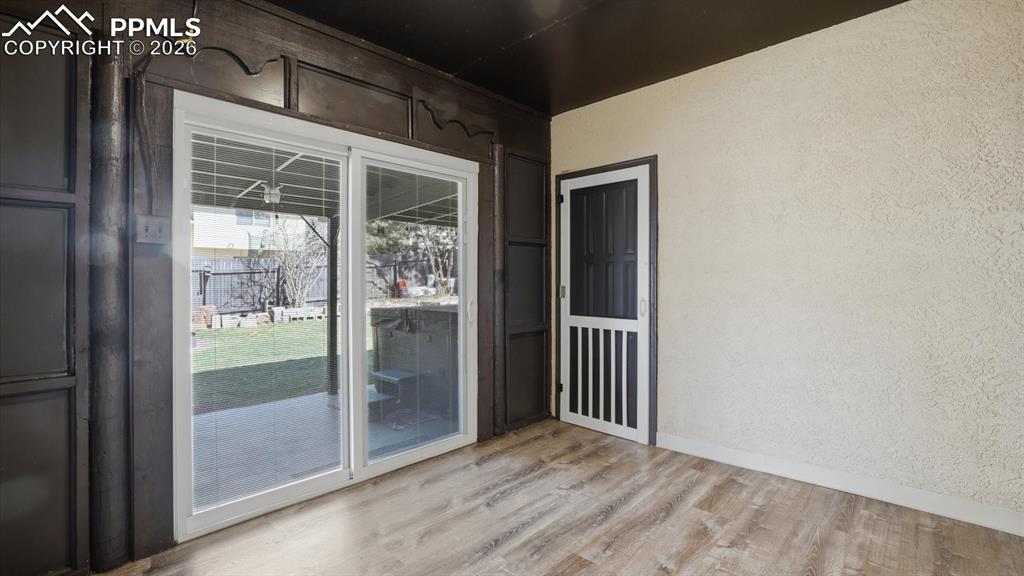 Image 10 of 50: Tranquil Sunroom with sliding glass doors opening to a covered patio with h