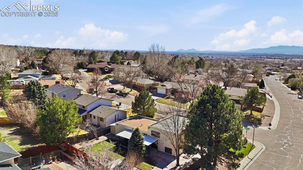Image 49 of 50: Fenced backyard with planter beds and covered patio with hot tub.