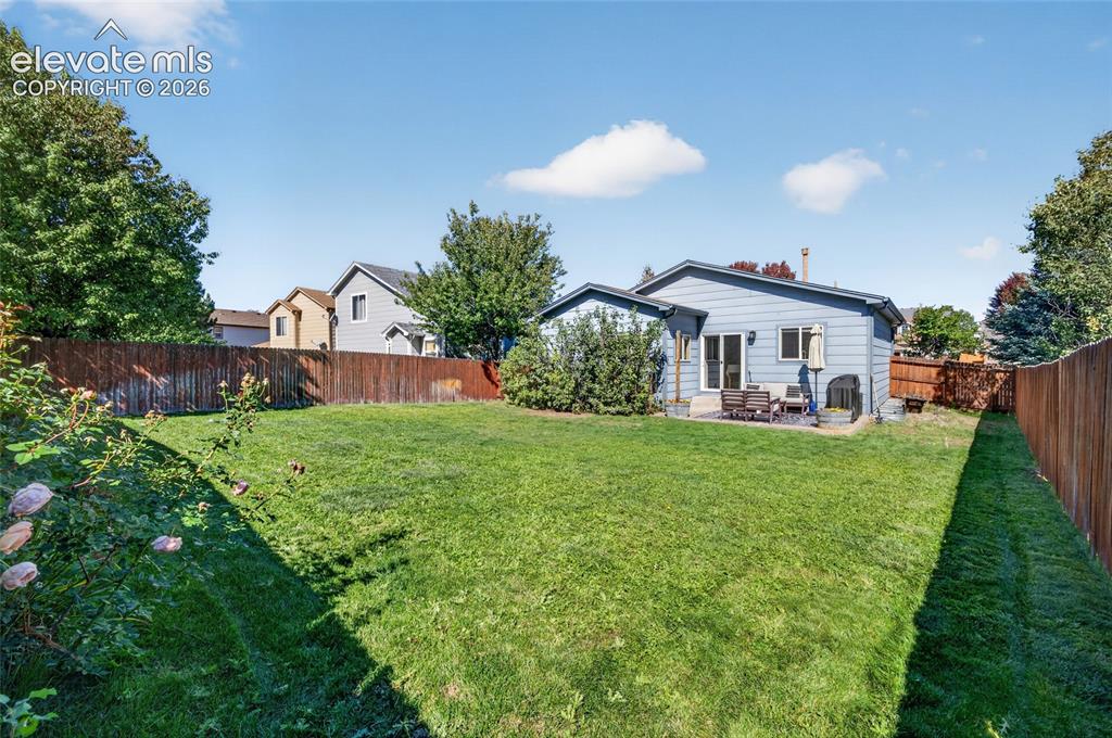 Image 24 of 31: Large, level backyard with auto sprinkler system