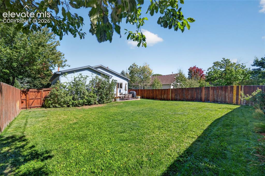 Image 25 of 31: Large, level backyard with auto sprinkler system