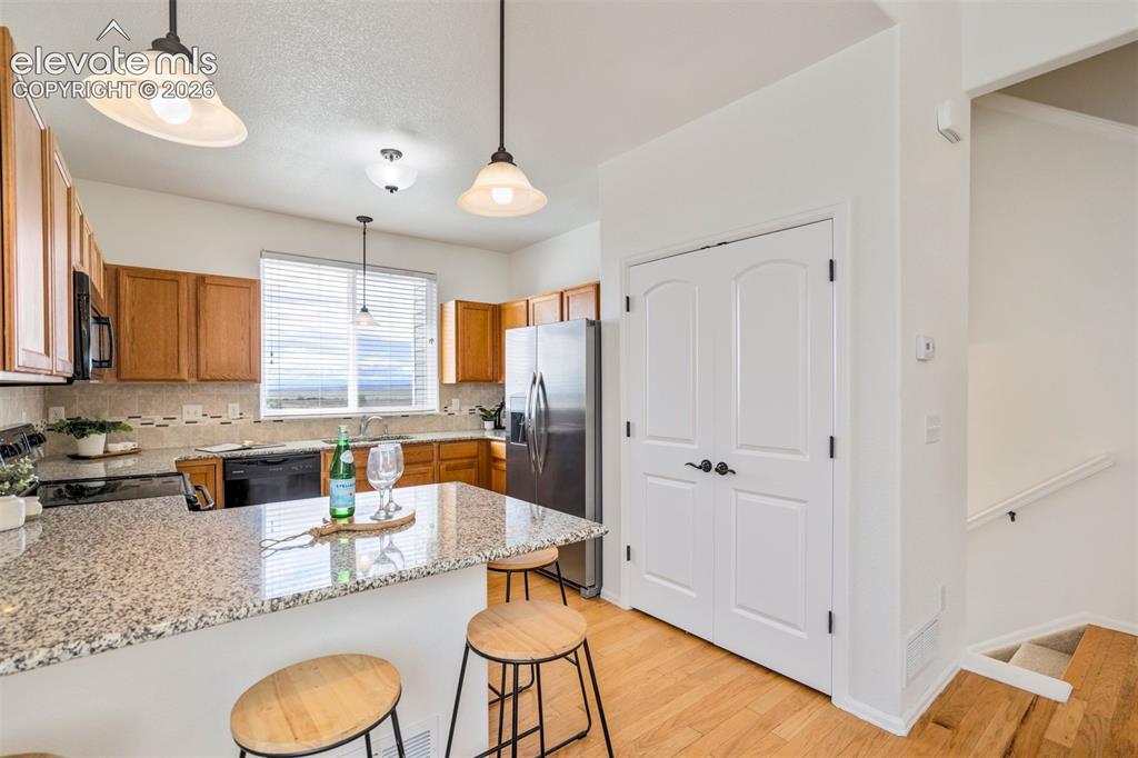 Image 11 of 39: Granite counters, a large pantry and additional seating space.