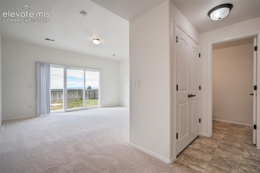Image 14 of 39: Lower level Family Room with a powder bathroom & access to the garage. 